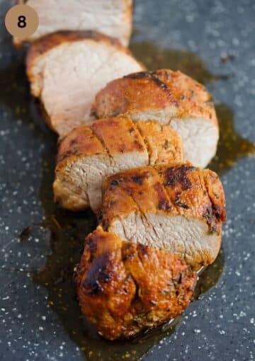 sliced tenderloin oozing juices on a cutting board.