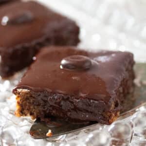 piece of chocolate cake traybake on a cake lifter.