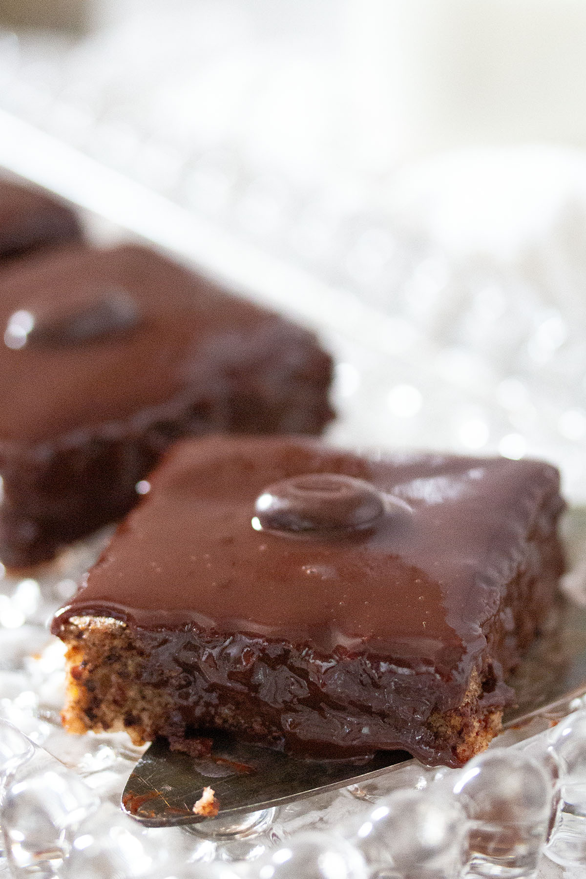 one square piece of chocolate cake on a cake platter.