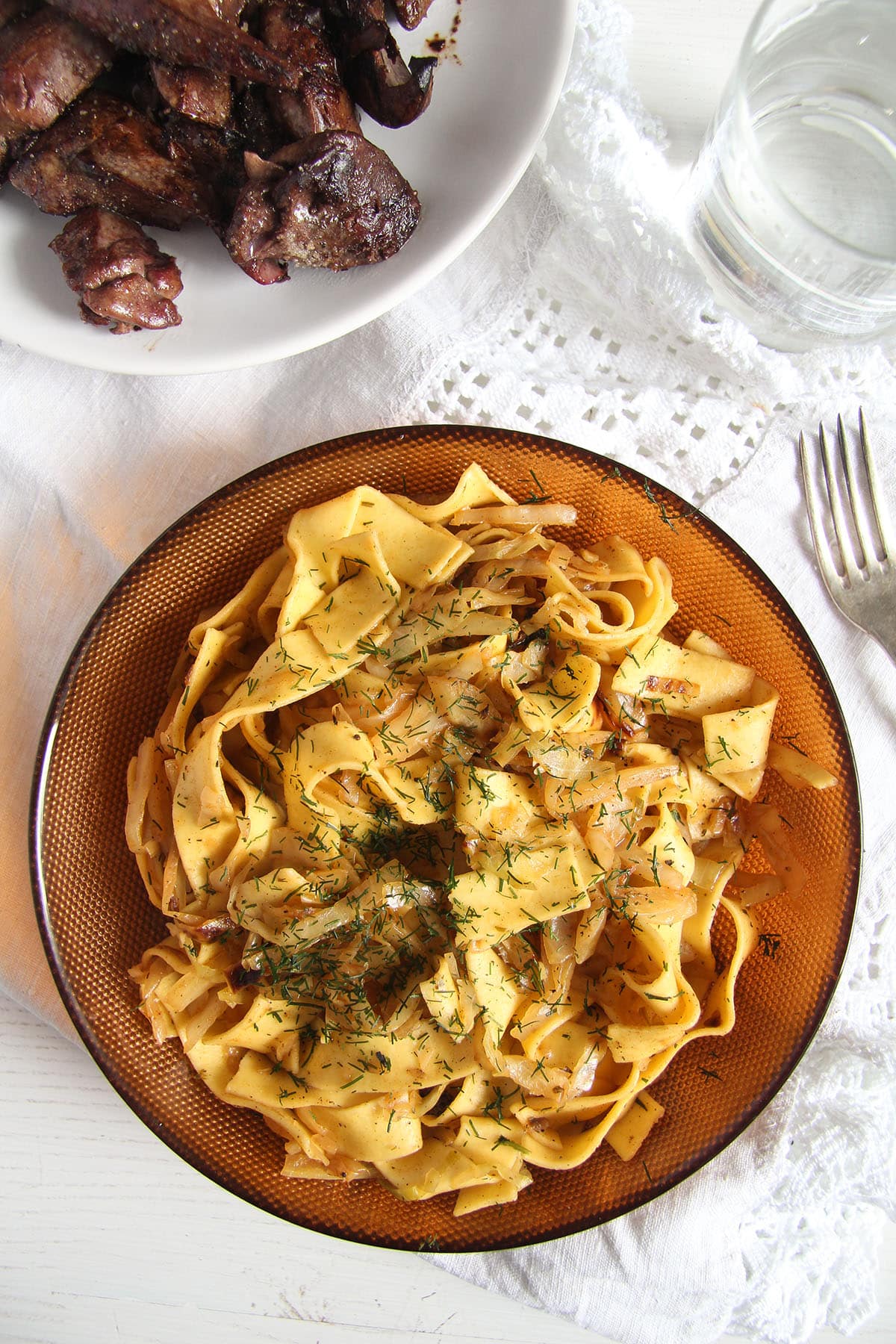 fried cabbage with noodles in a bowl and fried liver beside it.