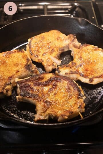 cooking marinated chops in a skillet on the second side.