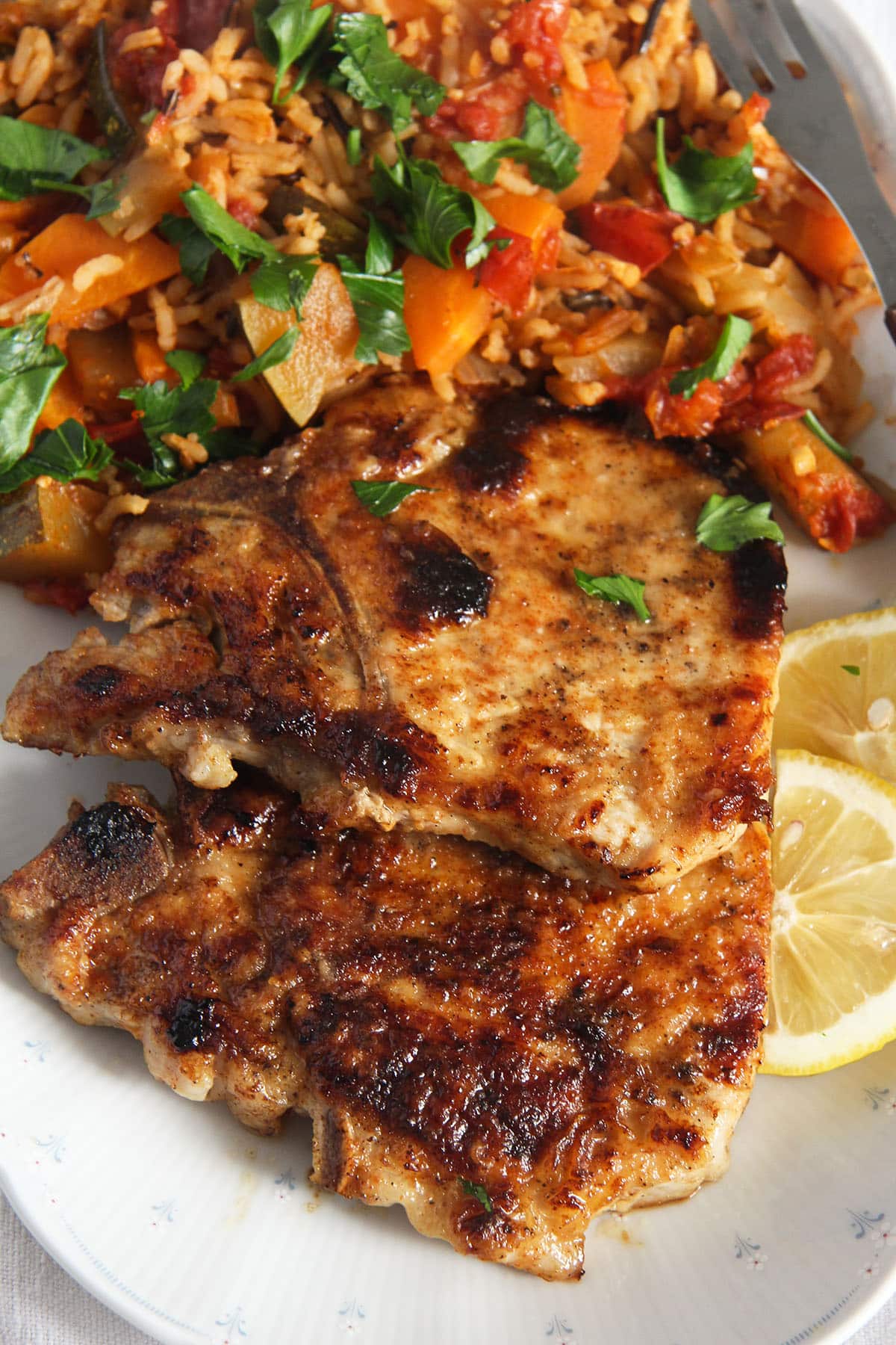 golden brown pork chops served with rice. 