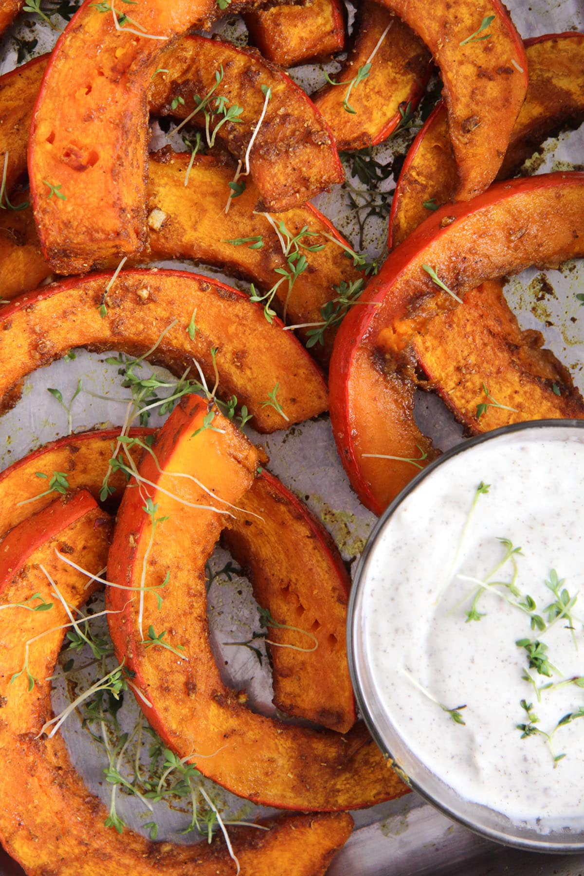 roasted pumpkin wedges with a bowl of dip. 
