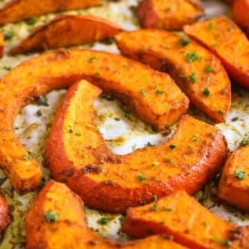 many spicy roasted pumpkin wedges sprinkled with parsley.