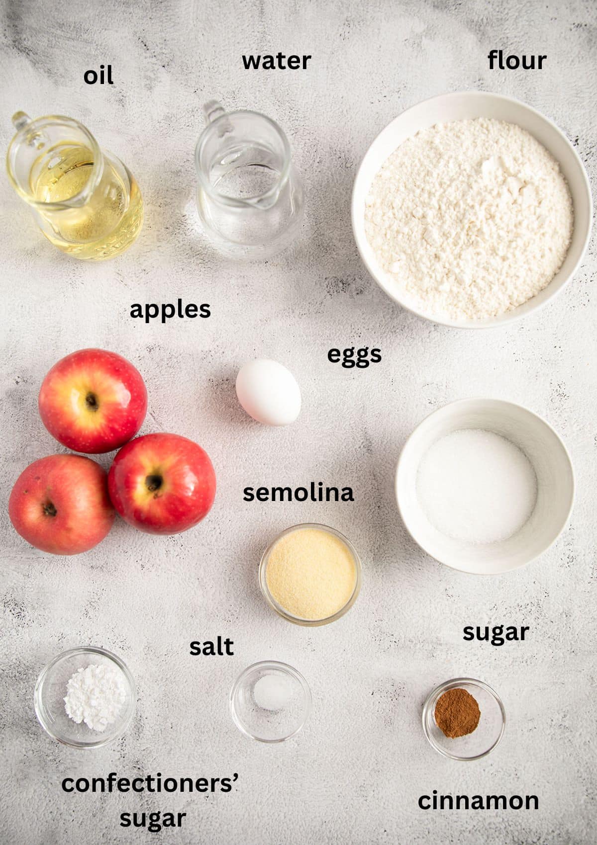 labeled ingredients for making pie with apples, flour, oil on the table.