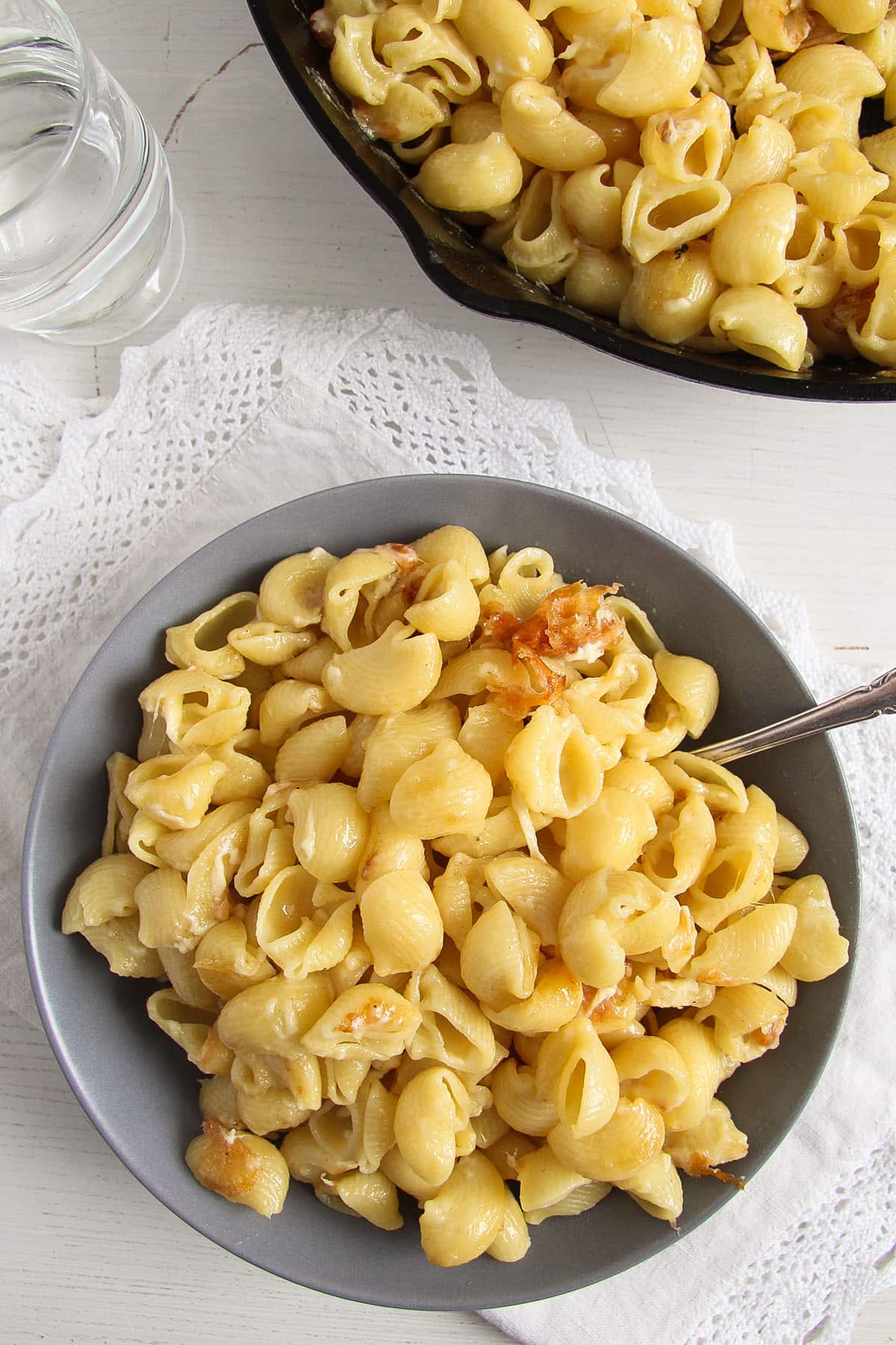 bowl with romanian macaroane cu branza, more in a skillet.