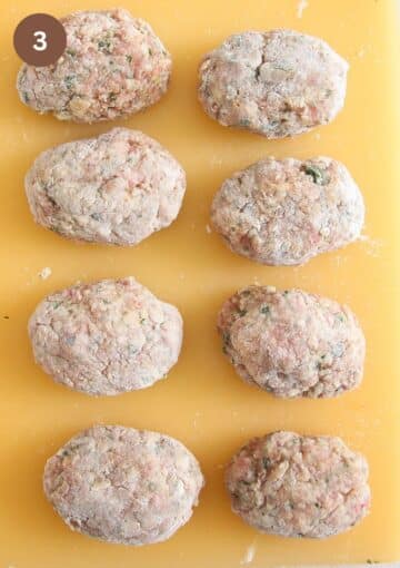 raw meatballs coated with flour on a cutting board.