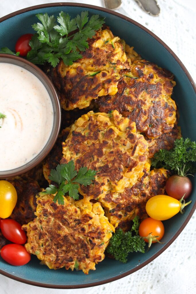 zucchini corn fritters served with yogurt dip and tomatoes