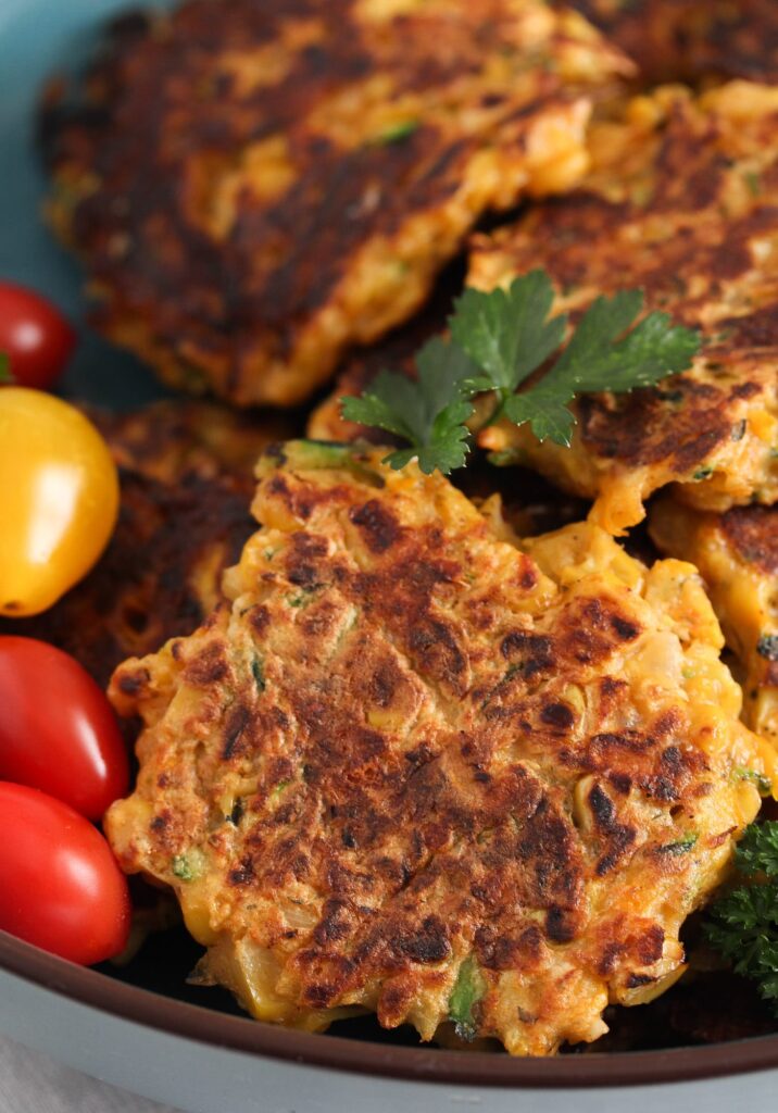 fritters with zucchini and corn in a large blue bowl
