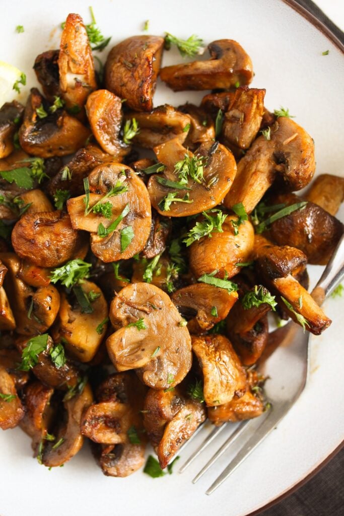 air fried mushrooms served on a white plate with a fork