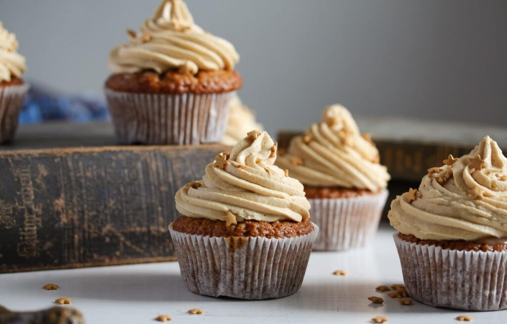 butterscotch muffins frosted with cream arranged on old books