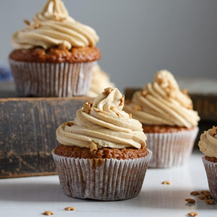 butterscotch muffins frosted with cream arranged on old books