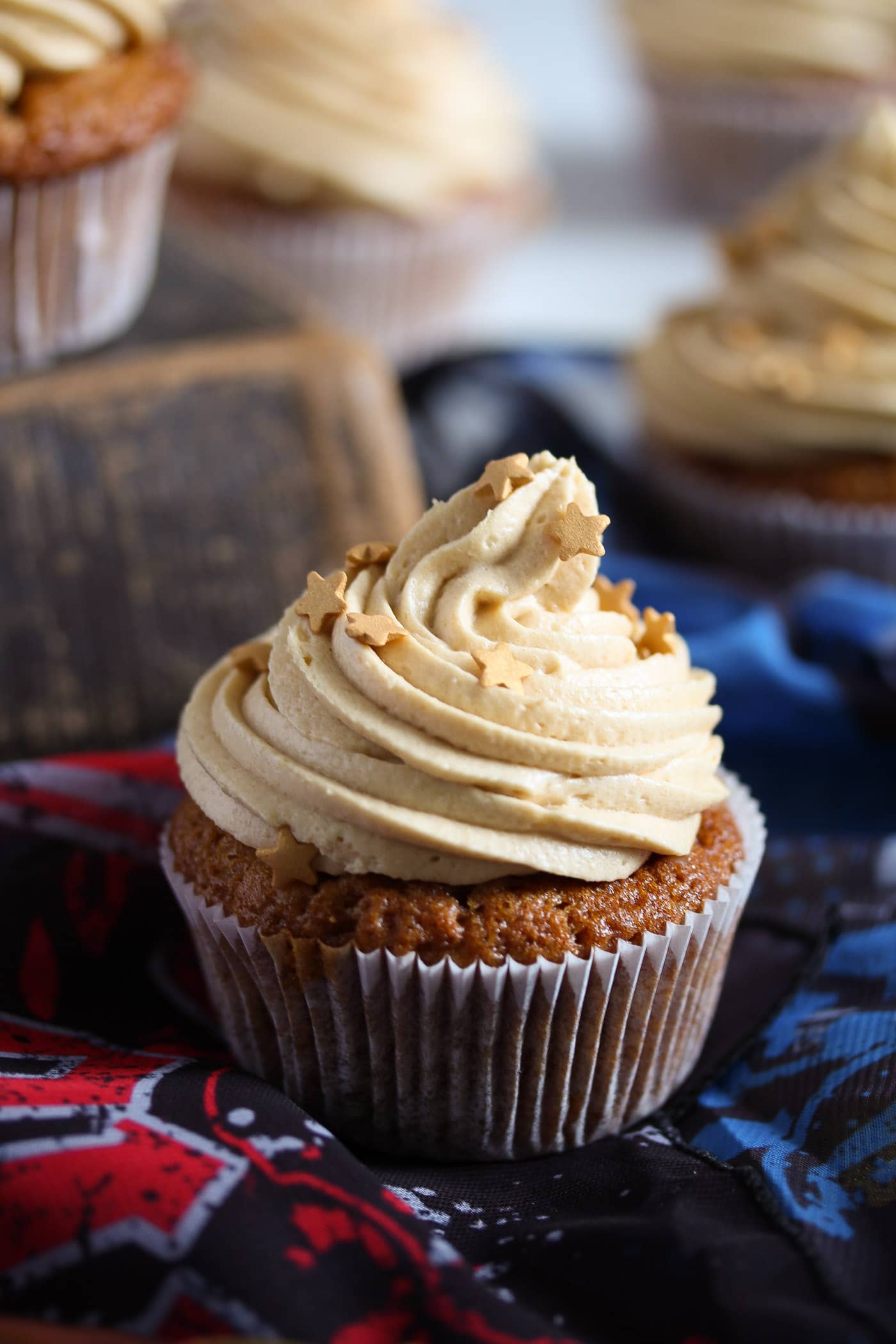 cupcake with butterscotch frosting on blue and red scarves