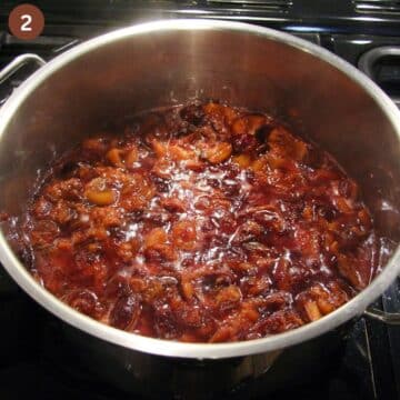 chopped plums cooking in a pot to make german plum butter.