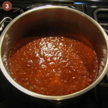cooking jam with plums in a large pot.