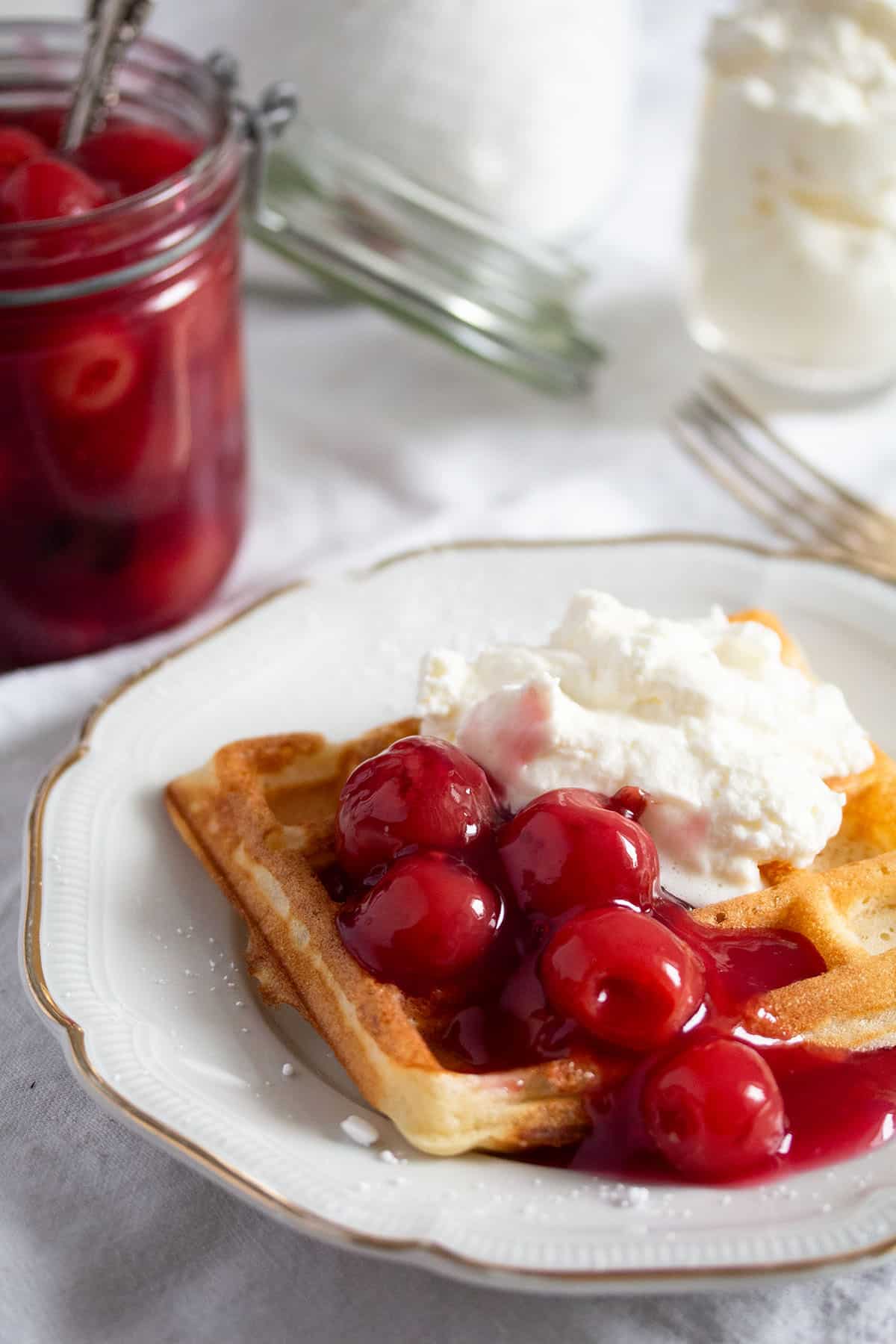 german-style waffles served with whipped cream and cherry sauce.