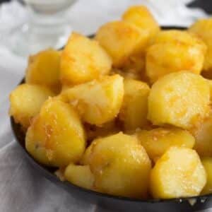 a bowl full of icelandic caramelized potatoes that are golden and slightly sugary.