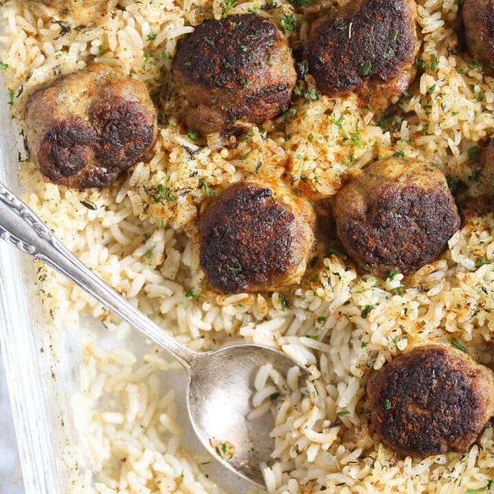 meatballs and rice being served with a spoon