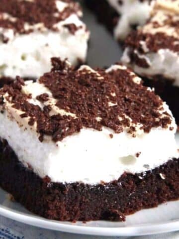 one meringue brownies topped with melting chocolate flakes, several others behind it.