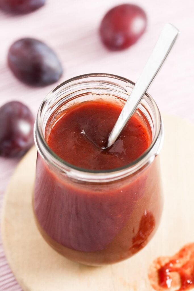 jar of german plum jam with a spoon in it