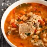 pin image for hearty pork rib soup with white beans and vegetables.