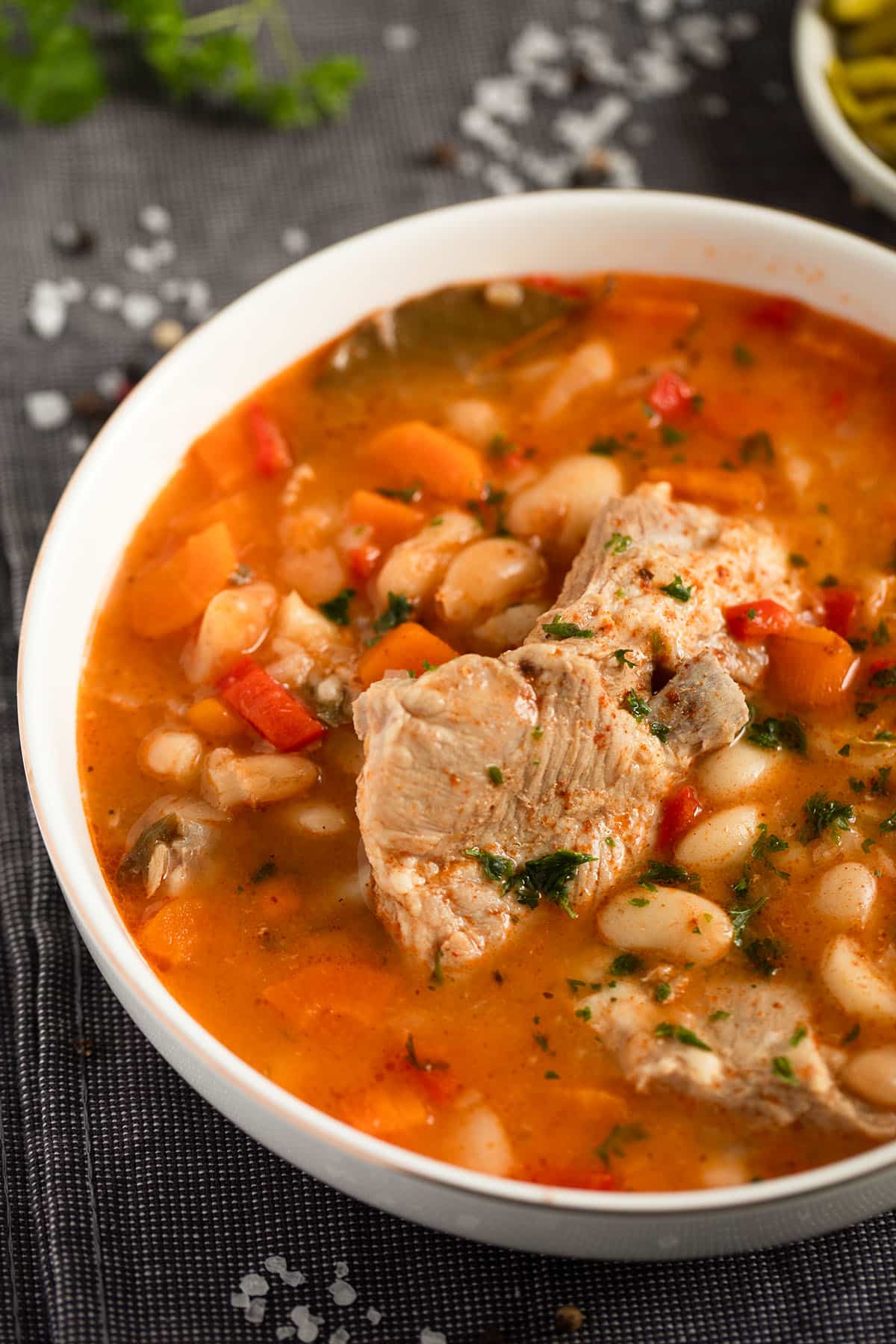 Bowl of homemade pork rib soup, showing tender ribs and white beans.