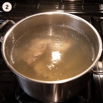 pork ribs being cooked in a large pot full of water.