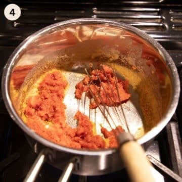 whisking tomato paste into flour roux in a small saucepan.