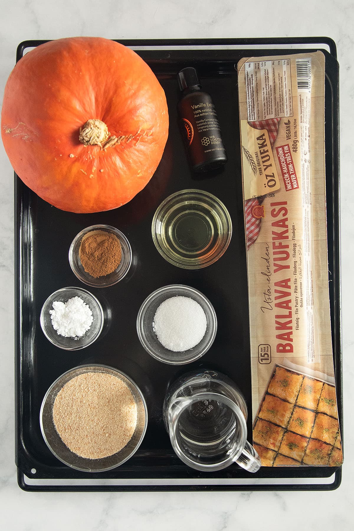 labeled ingredients for making filo pie with pumpkin and spices.