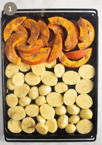 raw potato slices and pumpkin wedges sprinkled with spices on a sheet pan before baking.