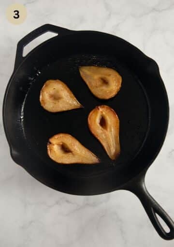 four roasted pears in a cast iron skillet.