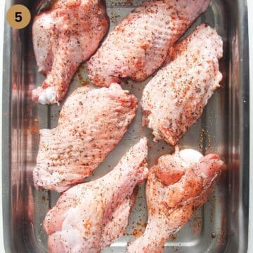 seasoned turkey wings on a roasting tin.