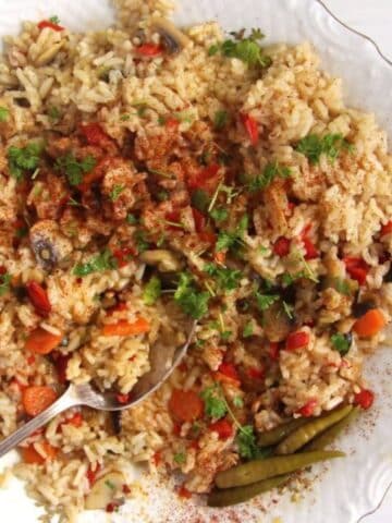 romanian vegetable rice or pilaf on a plate with a spoon in it.