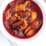 plums in sauce in a white bowl