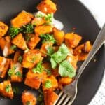 sweet potato cubes sprinkled with cilantro on a brown plate