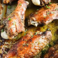 baked turkey wings in a roasting tin with parsley