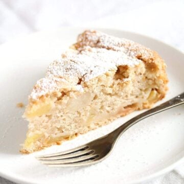 eggless apple cake sliced on a small plate with fork.