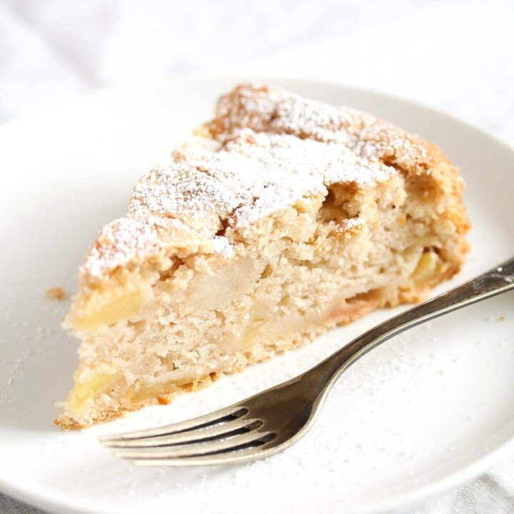 vegan apple cake sliced on a small plate with fork.