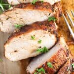 air fryer pork fillet sliced on a cutting board.