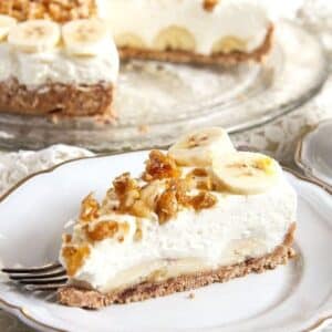a super creamy slice of banana cream caramel pie topped with candied walnuts and banana slices.