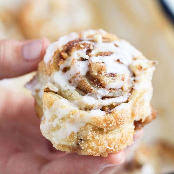 child holding one puff pastry cinnamon roll in the hand