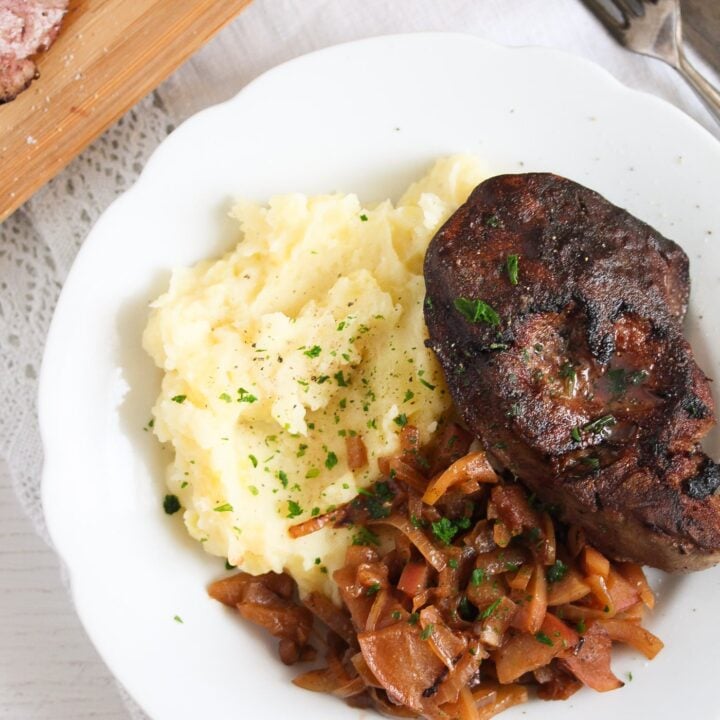 turkey liver served with mashed potatoes and onion apple sauce on a white plate