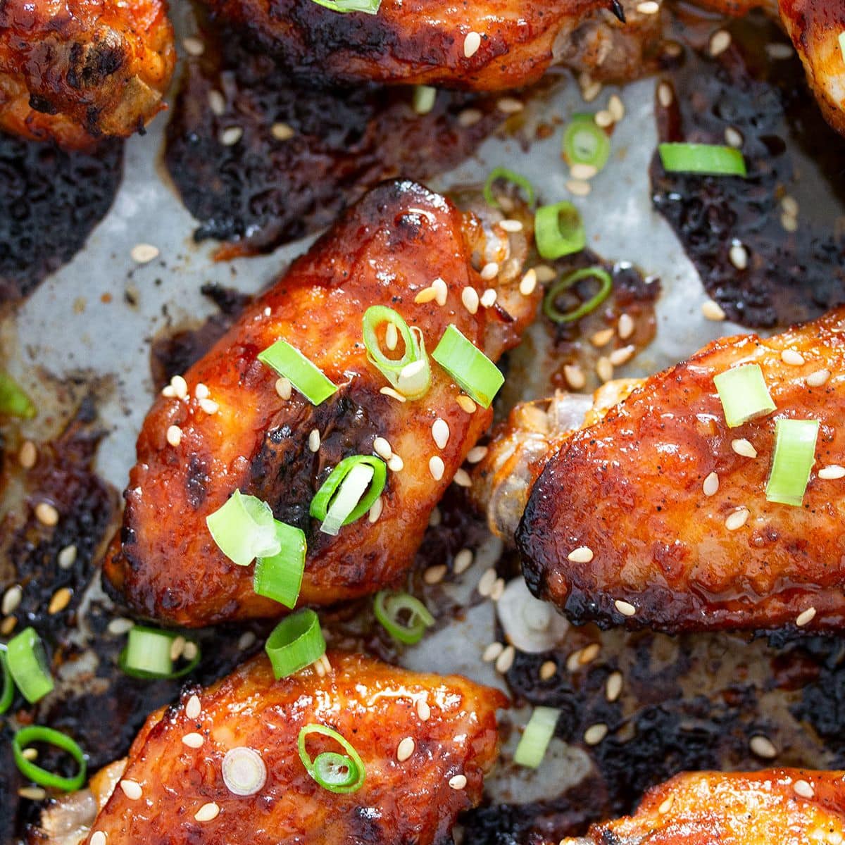 gochujang chicken wings sprinkled with sesame seeds and green onions.