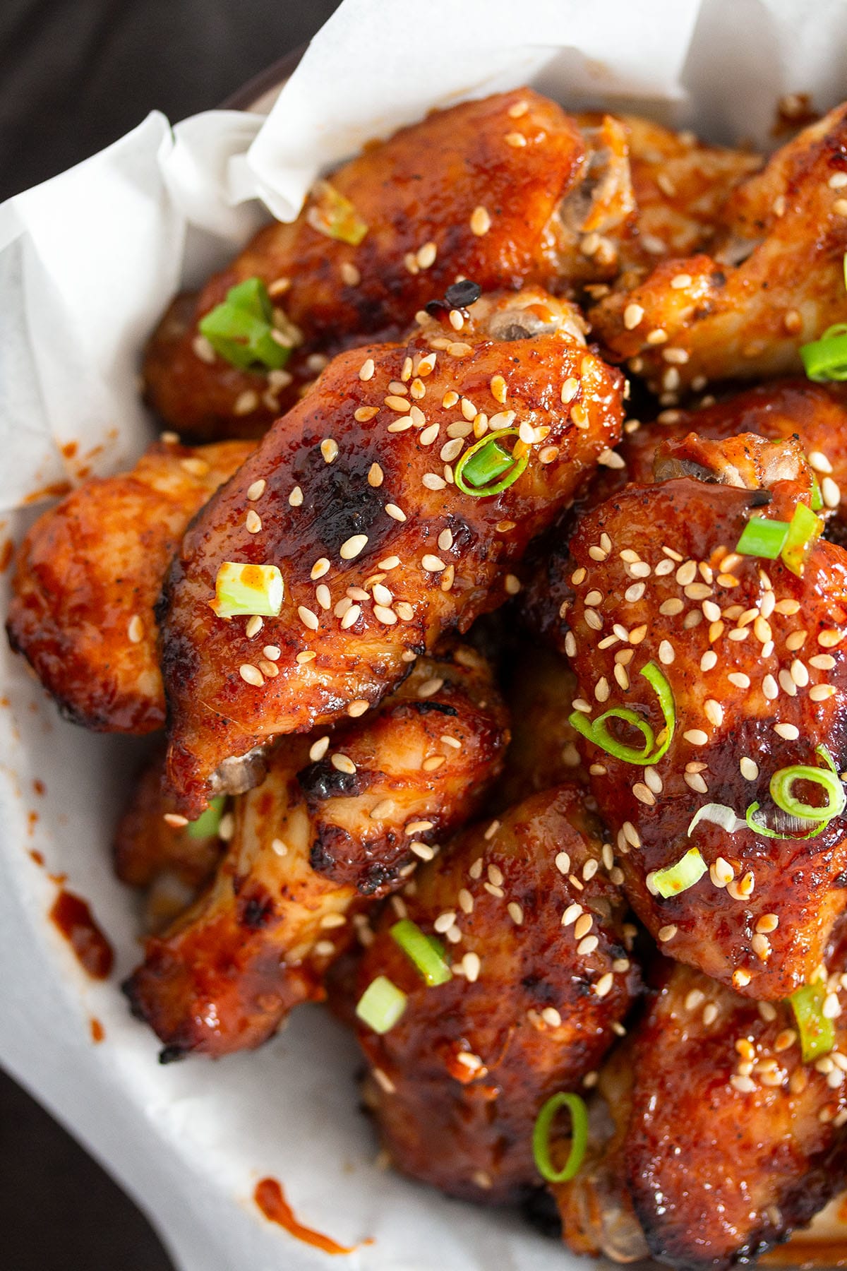 baked gochujang wings sprinkled with sesame seeds and spring onions.