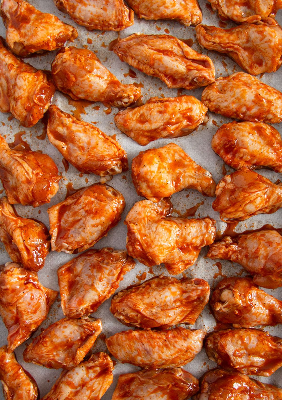 unbaked chicken wings on a baking sheet.