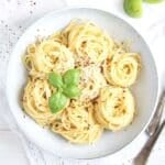 green tomato sauce with pasta in a white bowl.