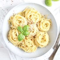 green tomato sauce with pasta in a white bowl.