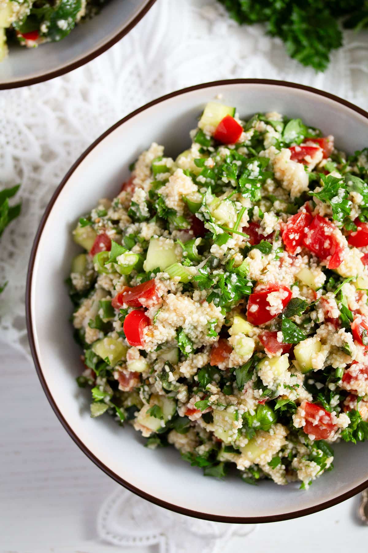 bowl of mediterranean salad with parsley, cucumbers, and bulgur.