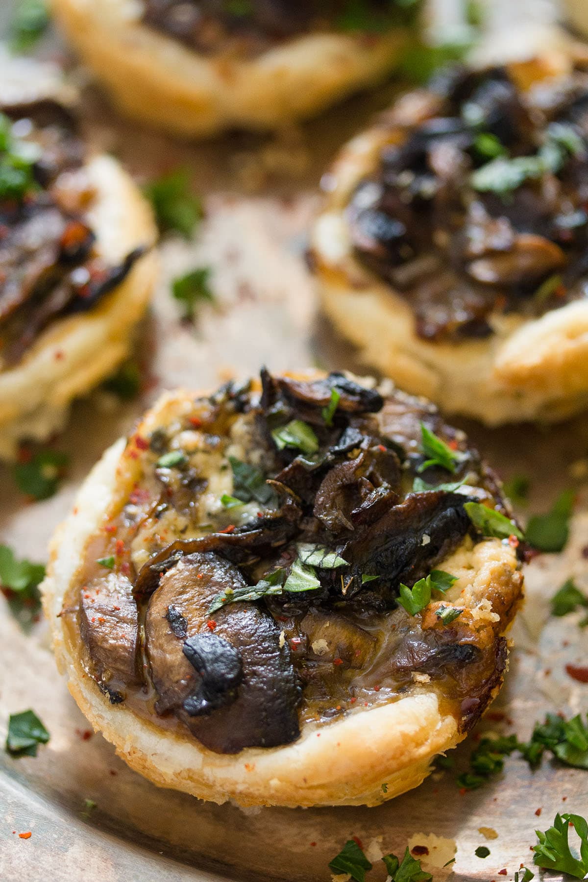 mini puff pastry mushroom pies sprinkled with chopped herbs.