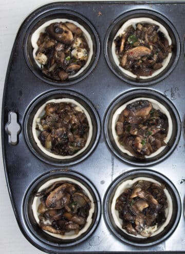 muhsroom pies in a muffin tin before baking.